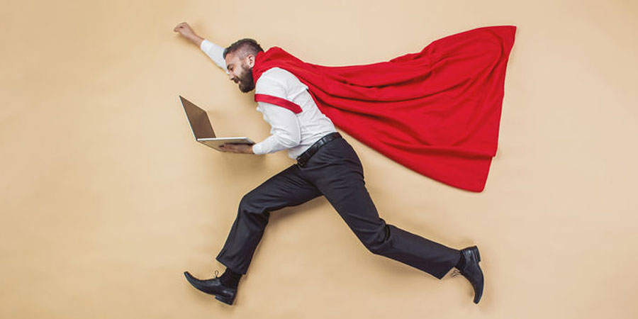 Businessman wearing cape with arm in air.