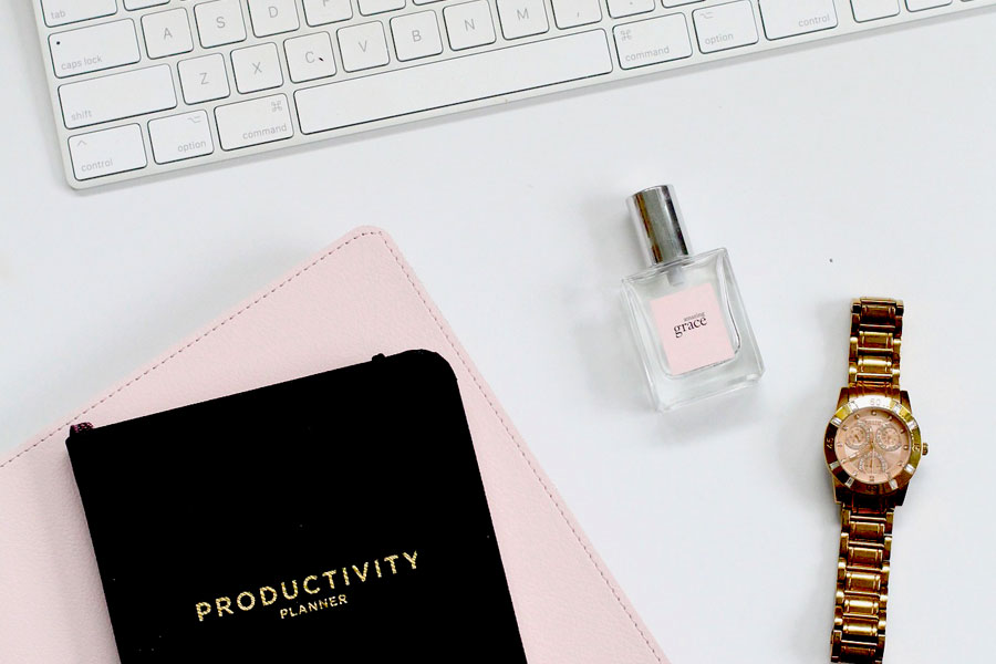 clean desk with Apple keyword, watch, perfume or cologne and productivity journal